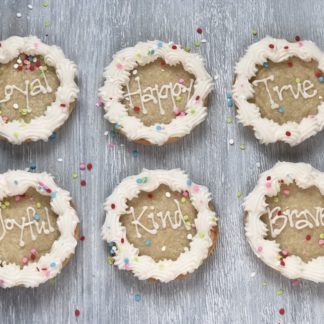 6 round sugar cookies with words Loyal, Happy, True, Kind, Joyful, and Brave